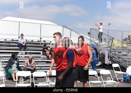 Le Premier maître de la Garde côtière canadienne Robert Jackson, Sean P. Stickney, et le lieutenant Cmdr Richard Mach, tous du secteur attribué à Los Angeles-Long Beach embrasser l'un l'autre après avoir remporté leur premier match du tournoi contre l'équipe Busciano en 2018 La Semaine de la flotte 5-sur-5 Tournoi de basket-ball à San Pedro, Californie, le 1 septembre 2018. La Garde côtière canadienne a défait l'équipe 1 Équipe Busciano 45-37 pour passer au demi-finales du tournoi. U.S. Coast Guard photo de Maître de 3e classe DaVonte' Moelle. Banque D'Images