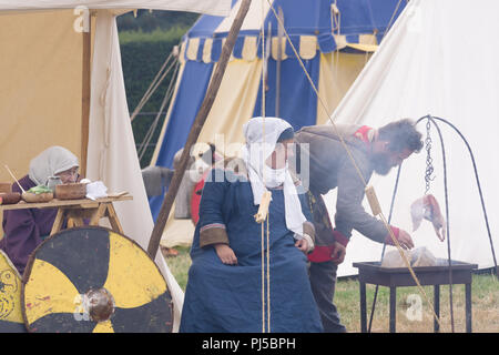 Reconstitution médiévale de la vie dans un camp avec des femmes habillées dans les costumes d'époque et la cuisine Banque D'Images