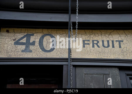 Ancien années 30 enseignes commerciales sur un mur par l'église de Spitalfields dans la ville de London,UK Banque D'Images