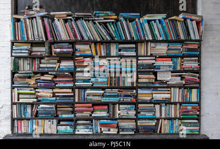 L'honnêteté des étagères à l'extérieur d'une librairie à Eastbourne. Quiconque achète un livre a pour l'argent comptant par la poste aux lettres lorsque le magasin est fermé. Banque D'Images