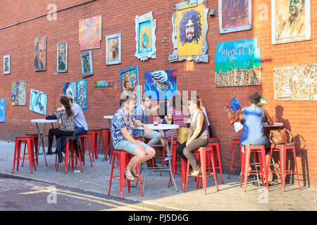 Les gens s'asseoir dans le jardin d'art portraits de rue, un café et un espace d'art communautaire en place de ruche, Brixton, dans le sud de Londres, UK Banque D'Images