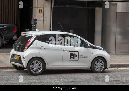 Les agents de stationnement ou civile dans une petite voiture contrôle des voitures en stationnement illégalement dans le centre de la ville de Londres. Banque D'Images