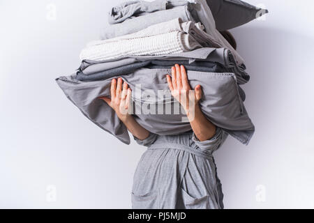 Les mains tenant gradient gris blanc monochrome de la pile de linge de lit noir textiles Vêtements background concept pile Banque D'Images