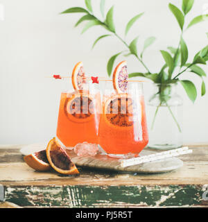 Deux verres d'alcool italien Aperol Spritz cocktail avec de la glace et le sang des tranches d'orange sur la table en bois, selective focus, copy space, square culture. Summ Banque D'Images