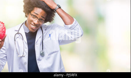 Médecin cardiologue african american man sur fond isolé a souligné avec la main sur la tête, choqué par la honte et la surprise face, en colère et frustrés. Banque D'Images