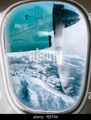 Widerøe Dash 8 vol d'un avion au-dessus des montagnes enneigées en Norvège Banque D'Images