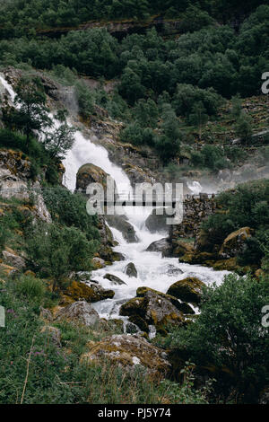 Pont sur l'eau qui coule du Glacier Briksdal dans le Parc National de Jostedalsbreen, Norvège Banque D'Images