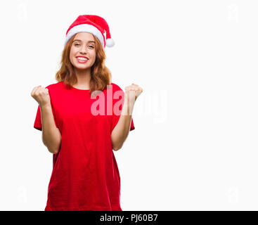 Belle jeune femme de plus fond isolé wearing christmas hat célébrant étonné et surpris du succès avec bras levés et ouvrir les yeux. Winn Banque D'Images