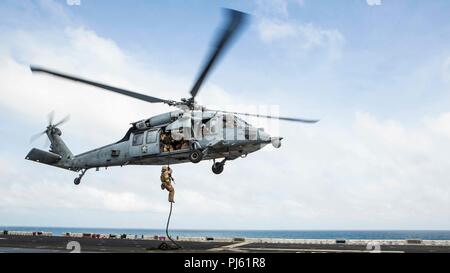 Océan Indien - U.S. Marine Lance Cpl. Alexandre Huynh, un carabinier avec Lima Company, bataillon de l'équipe d'atterrissage (BLT) 3/1, 13e Marine Expeditionary Unit (MEU), fast-cordes d'un hélicoptère MH-60 à bord de la classe Wasp-navire d'assaut amphibie USS Essex (DG 2), le 2 septembre 2018. Essex est le navire amiral de la Essex ARG et, avec l'entrepris 13e MEU, est déployé sur le 5e flotte américaine zone d'opérations à l'appui des opérations navales pour assurer la stabilité et la sécurité maritime dans la région Centrale, reliant la Méditerranée et le Pacifique à travers l'ouest de l'Océan indien et trois axes stratégiques Banque D'Images
