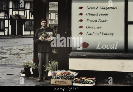 Commerçant asiatique se tenant devant son coin boutique, England, UK Banque D'Images