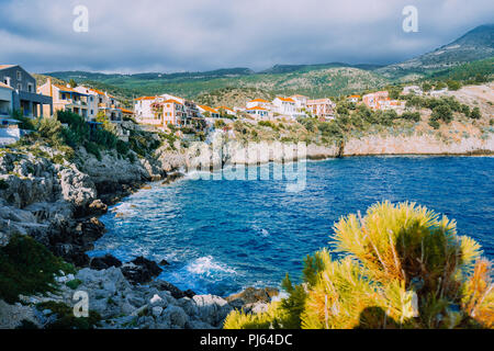 Littoral pittoresque village à Assos, l'île de Céphalonie en Grèce. Maisons colorées niché dans la falaise. Vacances d'été Banque D'Images