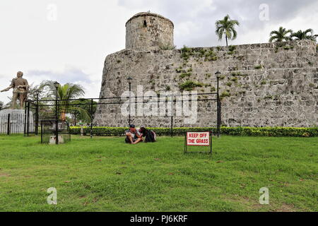 La ville de Cebu, Philippines-October 18, 2016 : Filipino couple assis sur la pelouse à côté de Fort San Pedro-Territoires du revêtement des murs en ignorant l'option -Marcher sur les Banque D'Images