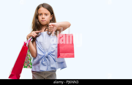 Brunette woman holding shopping bags with angry face, signe négatif montrant non avec vers le bas, le rejet de la notion Banque D'Images