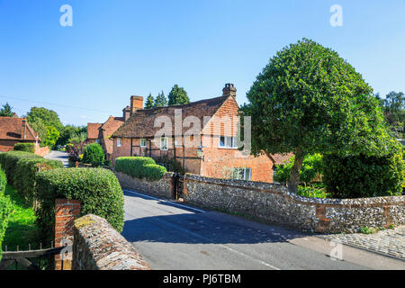 Joli chalet en bordure de l'église en brique rouge avec silex garden wall au Clandon, un petit village près de Guildford, Surrey dans le sud-est de l'Angleterre Banque D'Images