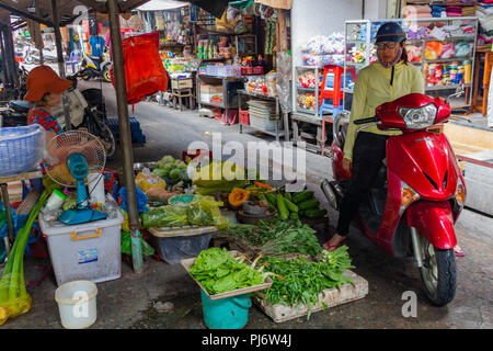 Ho Chi Minh Ville, en Asie - 12 mai 2018 : Les gens d'acheter des légumes à partir d'une moto dans un marché local Banque D'Images