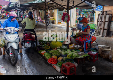 Ho Chi Minh Ville, en Asie - 12 mai 2018 : Les gens d'acheter des légumes à partir d'une moto dans un marché local Banque D'Images