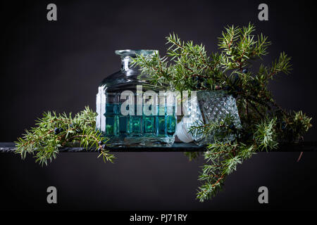 Carafe en cristal bleu Gin et genièvre baies avec la direction générale sur un fond noir. Banque D'Images