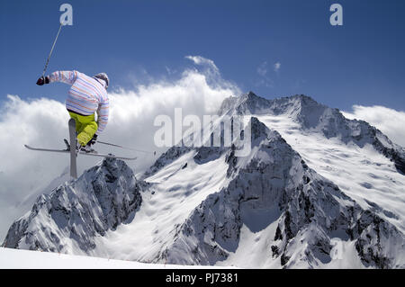Ski freestyle avec skis croisés dans les hautes montagnes enneigées en hiver jour soleil Banque D'Images