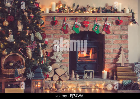 Réglage de Noël arbre de Noël décoré, arrière-plan, des pommes de pin dans le panier avec une cheminée sur l'arrière-plan, une des bougies de Noël, selective focus Banque D'Images