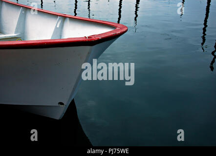 Dory rouge et blanc flottant sur des eaux calmes en Alaska, Seldovia Banque D'Images