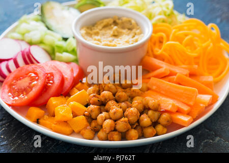 Close up of healthy vegan dinner plate, les pois chiches et les légumes sur le fond bleu Banque D'Images