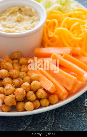 Snack vegan colorés, les pois chiches et les légumes sur le fond bleu, Close up Banque D'Images