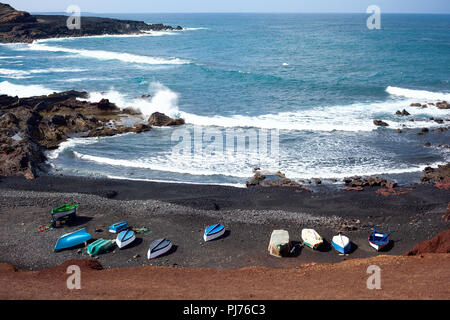 Vue sur la mer et les roches en El Golfo, Lanzarote, Canaries, bateaux sur la rive, selective focus Banque D'Images