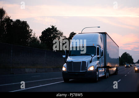 Big Rigs semi camions transportent des marchandises sur les routes sans interruption, quel que soit le moment du jour, de tôt le matin jusqu'à tard dans la nuit, les camionneurs sont Banque D'Images