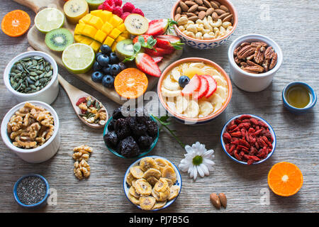 Des smoothies faits avec les satsumas, golden kiwi, mangue et banane avec des fruits et des petits fruits sur la table en bois, selective focus Banque D'Images