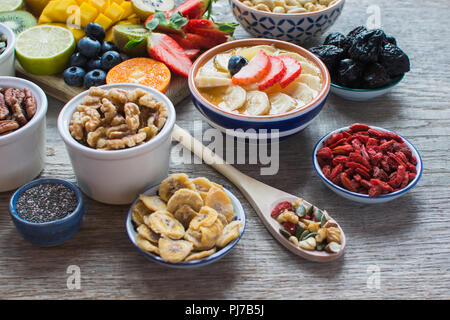 Des smoothies faits avec les satsumas, golden kiwi, mangue et banane avec des fruits et des petits fruits sur la table en bois, selective focus Banque D'Images