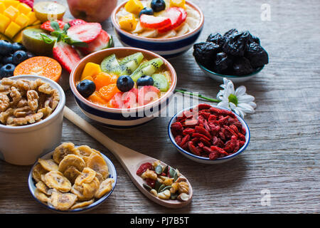 Des smoothies faits avec les satsumas, golden kiwi, mangue et banane avec des fruits et des petits fruits sur la table en bois, selective focus Banque D'Images