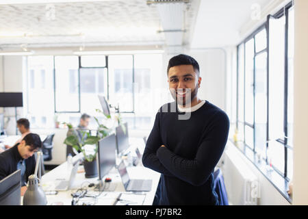 Portrait of smiling, confident businessman in open plan office Banque D'Images