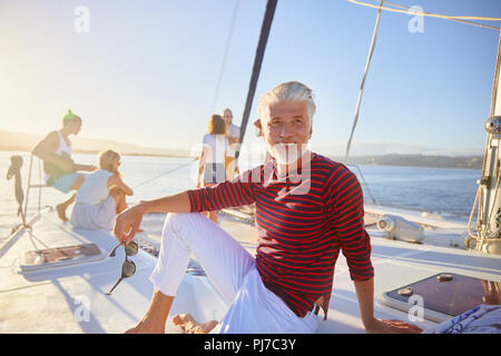 Portrait of smiling man relaxing on sunny boat Banque D'Images