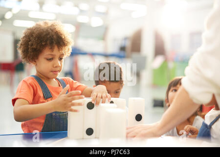 Curieux les enfants jouant avec de grands dominos en science center Banque D'Images