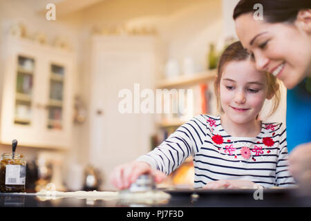 Mère et fille, la cuisson à l'aide de l'emporte-pièce dans la cuisine Banque D'Images