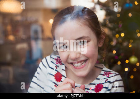 Portrait souriant, confiant fille dans un salon de Noël Banque D'Images