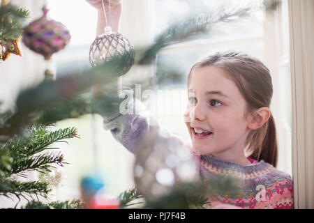 Girl decorating, ornement suspendu on Christmas Tree Banque D'Images