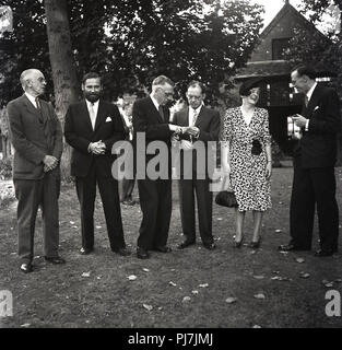 Années 1950, historique, groupe de messieurs bien habillés et une dame debout ensemble à une garden-party ou fonction, England, UK. Banque D'Images