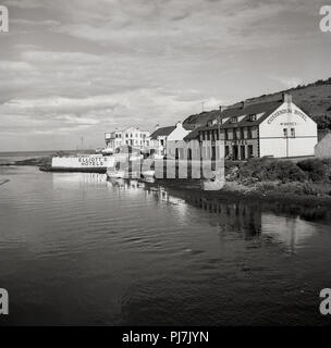 Années 1950, photo montre l'hôtel Cushendun dans le port, Cushendall, Co. d'Antrim, en Irlande du Nord. C'est le point le plus proche de la Grande-Bretagne. L'hôtel Cushendun dans l'avant-plan a été construit dans les années 1920 et possédé et dirigé par Mme McBride. Le Bay Hotel qui a ouvert ses portes en1936 peut être vu dans la distance. Banque D'Images