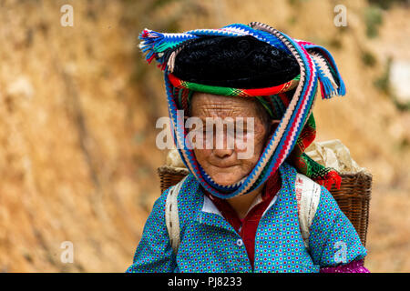 Ha Giang, Vietnam - Mars 18, 2018 : femme marche sur une route poussiéreuse près de champs agricoles dans le nord du Vietnam Banque D'Images