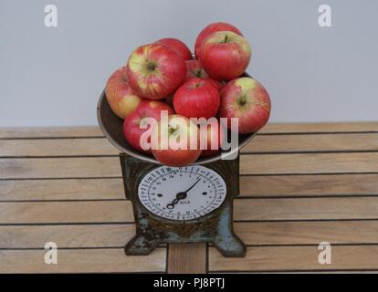 Pommes rouges sur une vieille balance de cuisine à temps vu de dessus Banque D'Images
