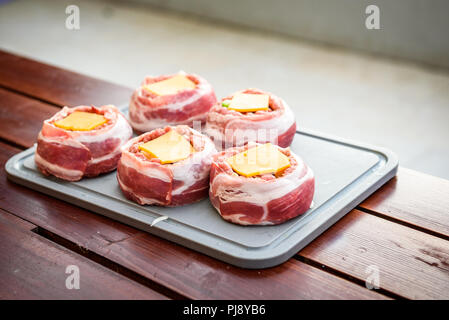 Faire de la bière fait maison peut Bacon les galettes sur le barbecue. Préparer les galettes farcies, enrobé de bacon. Banque D'Images
