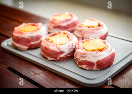 Faire de la bière fait maison peut Bacon les galettes sur le barbecue. Préparer les galettes farcies, enrobé de bacon. Banque D'Images