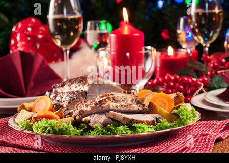 Longe de porc rôti avec pommes de terre au four et légumes. Ambiance de Noël Banque D'Images