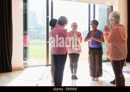 Smiling senior femmes faire de l'exercice, la pratique du yoga à sunny studio Banque D'Images