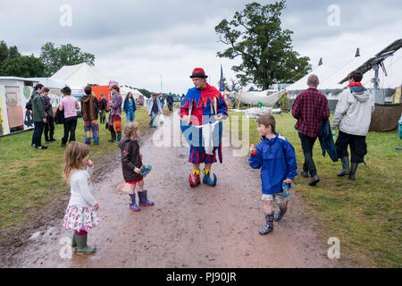 Chepstow, Pays de Galles - 15 Août : un clown coloré dans un bateau marche stupides costumes sur un pied-à propos de divertir un groupe de jeunes enfants le 15 août 2015 à e Banque D'Images