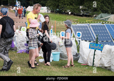 Chepstow, Pays de Galles - Aug 15 : Man & trois filles trier leurs déchets dans les bacs de recyclage à côté de la mise sous tension des panneaux solaires l'environnement Banque D'Images