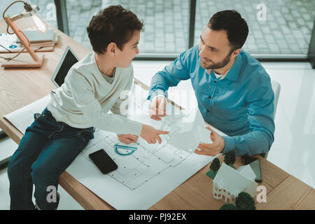 Cute boy positive pointant vers le modèle de la chambre Banque D'Images