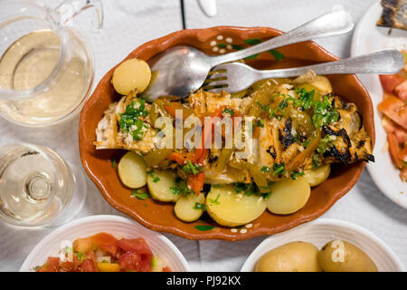 Poisson d'or portugais traditionnel avec du poivre rouge et vert servi avec pommes de terre cuites et tomates en salade Banque D'Images