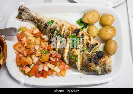 Grillades de Poisson d'or portugais traditionnel, servi avec des pommes de terre et salade de tomates Banque D'Images